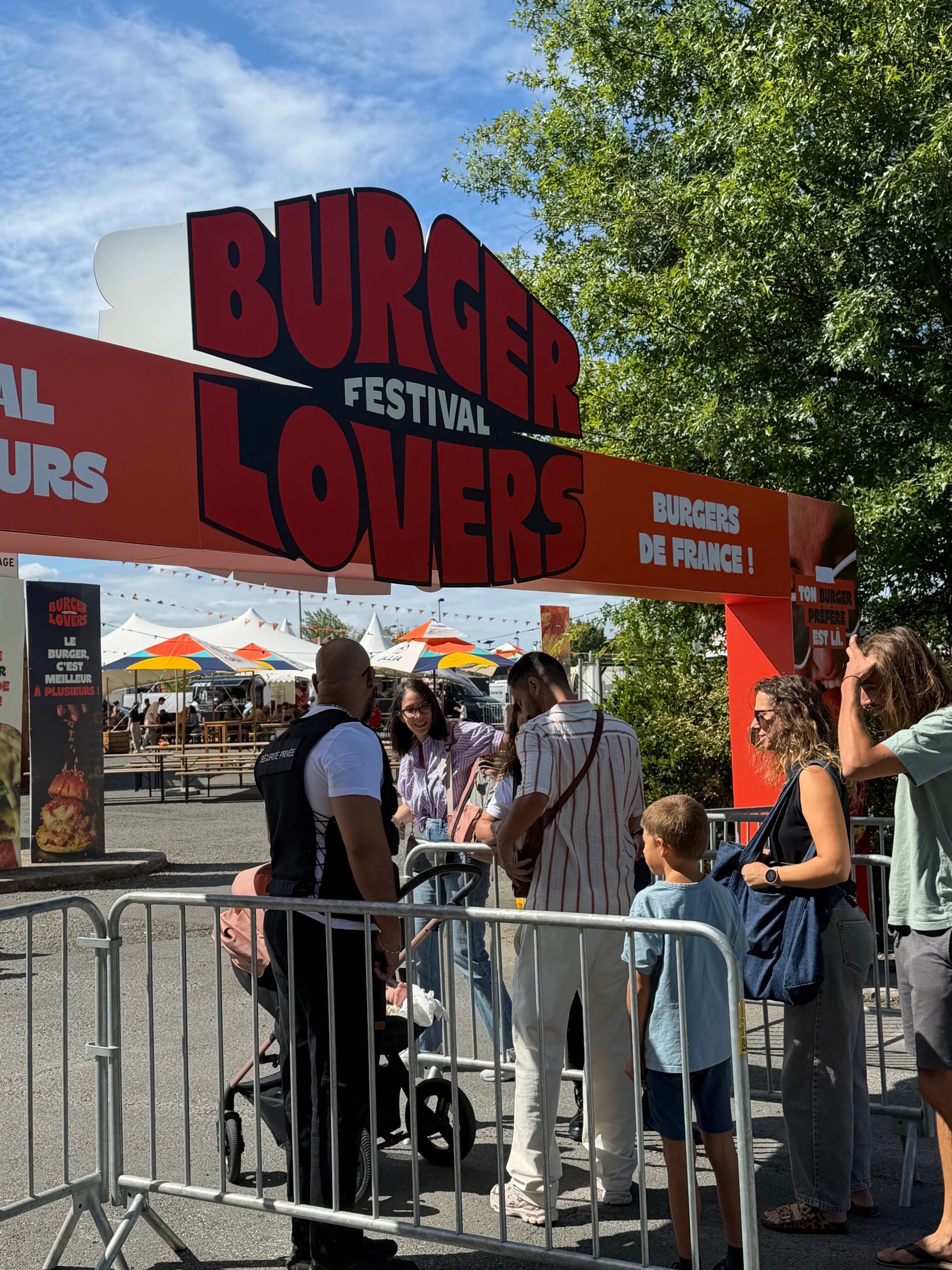 Agent de sécurité de dos à l’entrée d’un festival, devant les barrières de contrôle